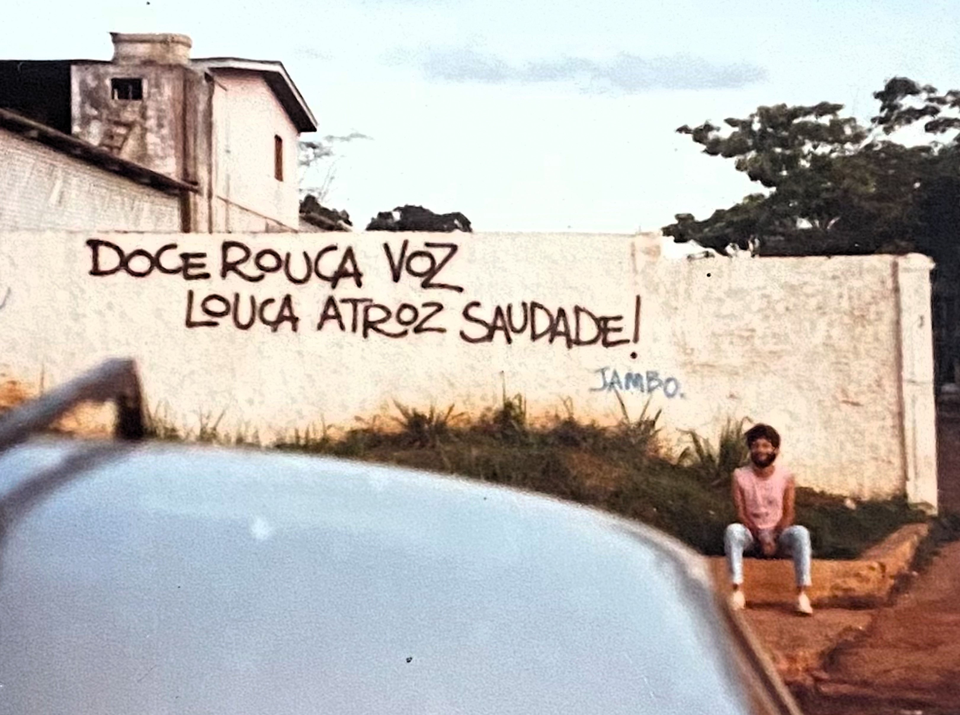 “Doce rouca voz, louca atroz saudade.” No grafite assinado por Jambo, a cidade transforma afeto e ausência em poesia urbana.